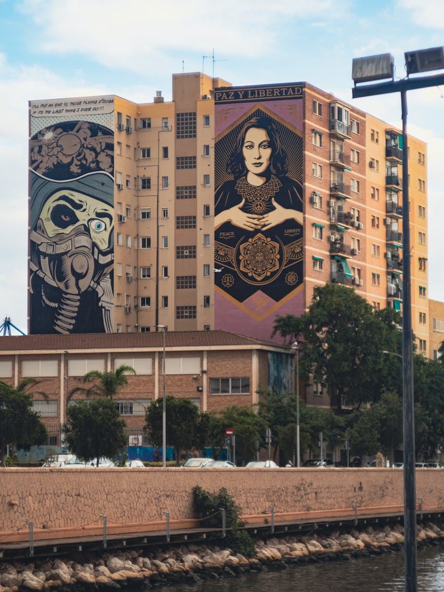 Vibrant murals adorn an apartment building, reflecting Málaga's urban art culture.